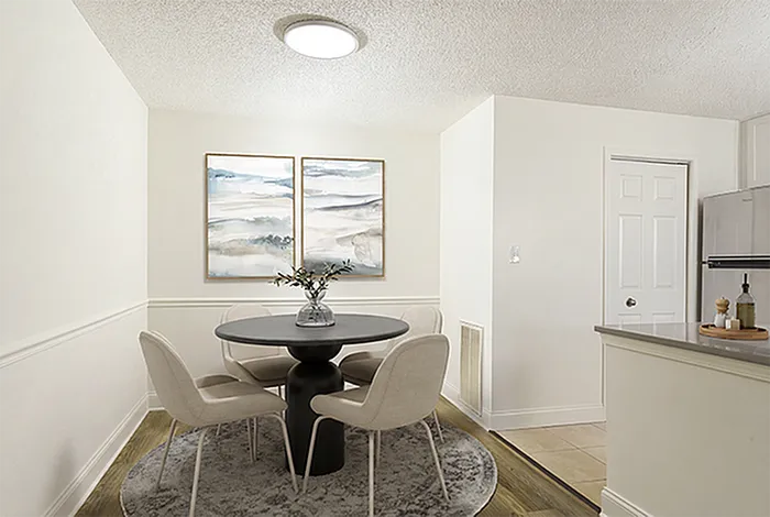 Chic dining area with modern round table setting, elegant artwork, and soft lighting.