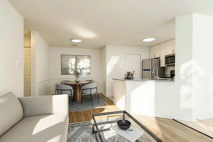 Bright and modern open-concept living space featuring a cozy seating area, sleek kitchen, and elegant dining nook.