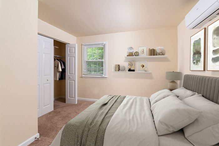 Inviting bedroom with neutral tones, cozy bed, large window, and an organized closet.
