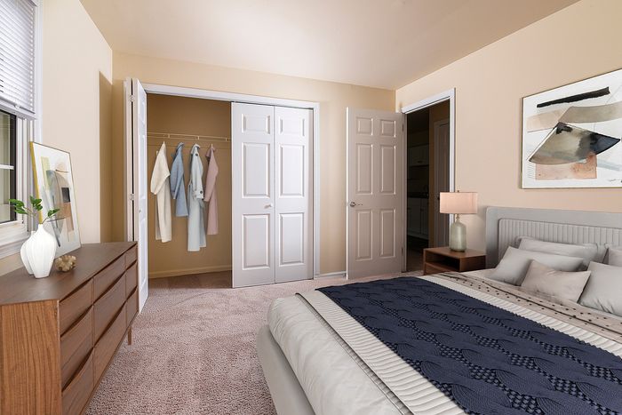 Bright and cozy bedroom with plush carpeting, stylish bedding, ample closet space, and modern decor.