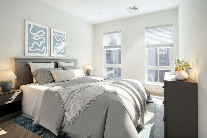 Bright and cozy bedroom with stylish decor, featuring a comfortable bed, soft bedding, and natural light streaming through large windows.