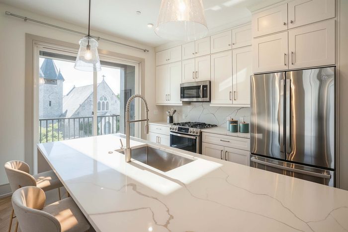 Bright kitchen with chic marble countertops, stainless steel appliances, and a stunning view of a historic church through large windows.
