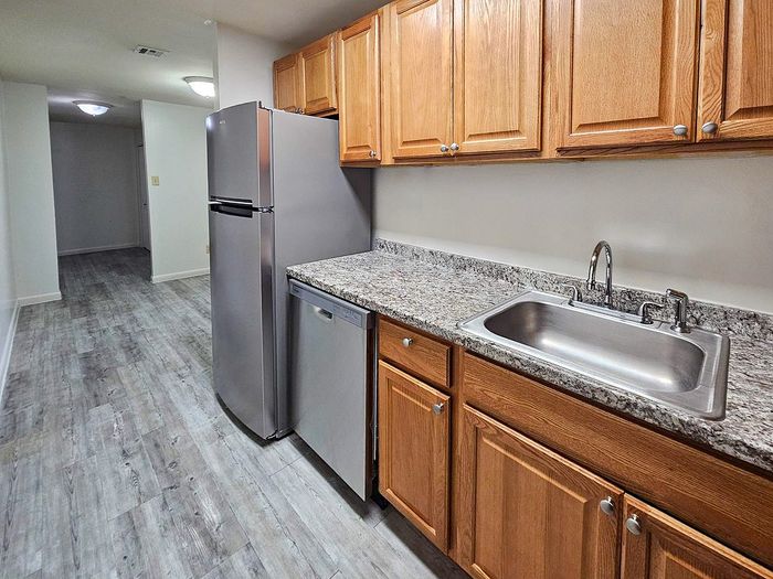 Modern kitchen with sleek stainless steel appliances, elegant wooden cabinetry, and stylish granite countertops.