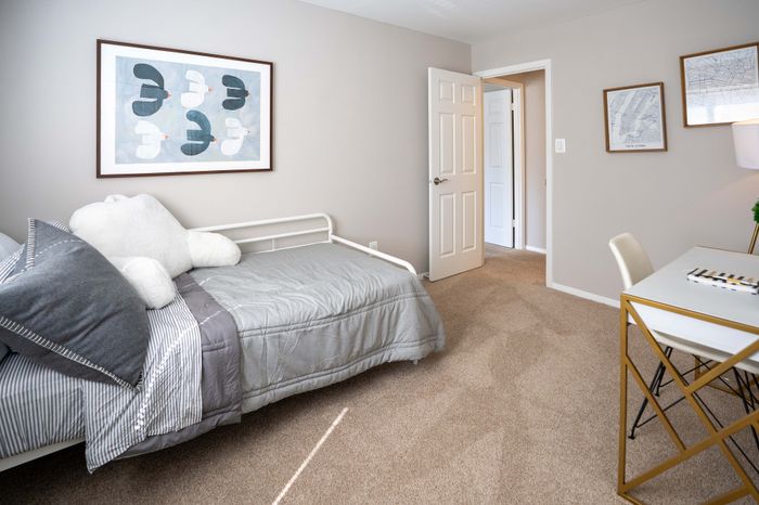 Bright and cozy bedroom with modern decor, featuring a comfortable single bed, elegant artwork, and a stylish study desk, ideal for relaxation and productivity.