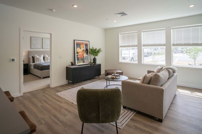 Bright and inviting living room with elegant decor, cozy seating, and large windows providing abundant natural light.
