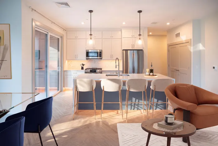 Modern kitchen with elegant island seating, warm lighting, and chic decor, ideal for entertaining and relaxing.