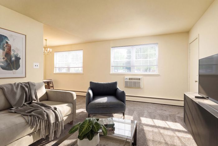 Bright and inviting living room with comfortable seating, modern decor, and large windows allowing plenty of natural light.
