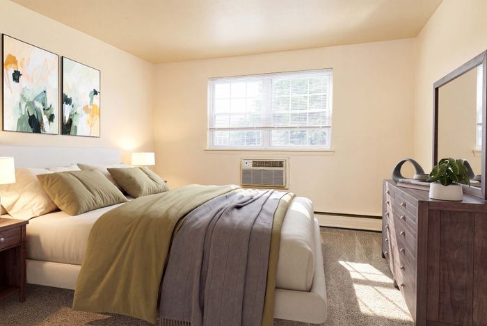 Bright and inviting bedroom with modern decor, large window, and cozy bedding.