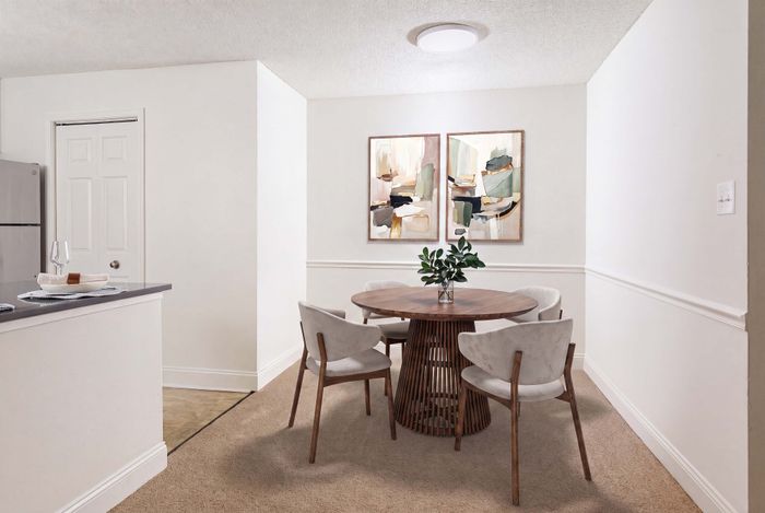 Charming dining area with a modern round wooden table, elegant chairs, and contemporary artwork on the wall, perfect for cozy meals.