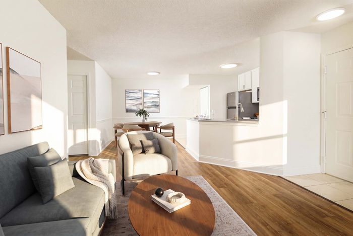 Modern open-concept living room with elegant seating, wooden floors, and a sleek kitchen design, perfect for stylish entertaining.