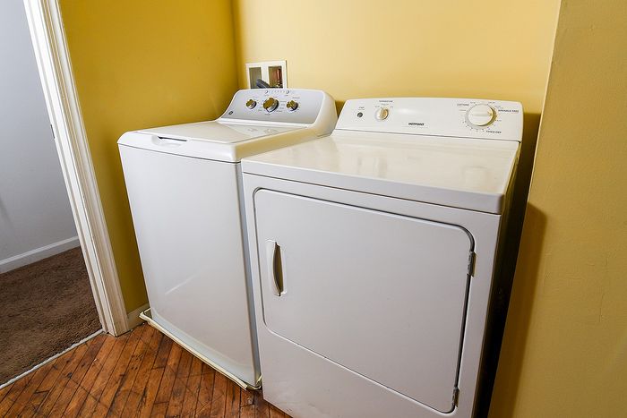 Charming laundry nook featuring a modern washer and dryer set against a vibrant yellow wall, adding functionality and style to your home.