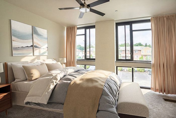 Bright and airy bedroom with modern decor, large windows, and scenic views.