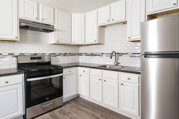 Sleek modern kitchen with stainless steel appliances, white cabinetry, and elegant subway tile backsplash.