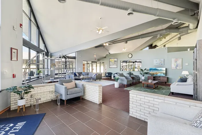 Modern lounge area with high ceilings, cozy seating, and elegant decor, perfect for relaxation and gatherings.