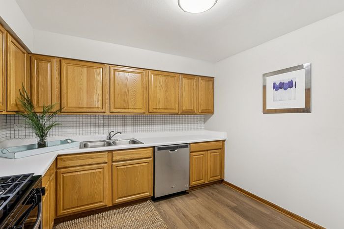 Bright and modern kitchen with sleek stainless steel appliances, elegant wooden cabinets, and a stylish backsplash, perfect for culinary creativity.