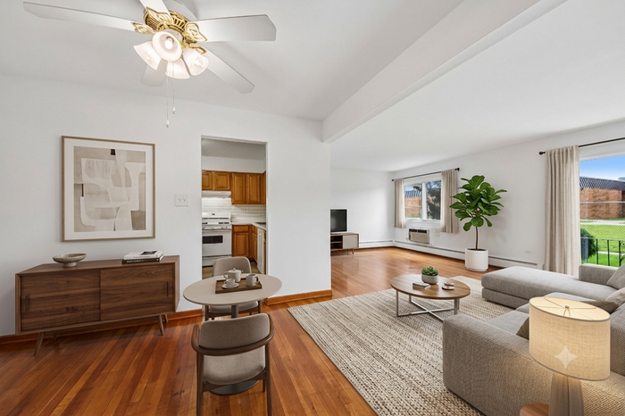 Charming open-concept living and dining area with elegant hardwood floors, featuring cozy furniture, modern decor, and ample natural light from large windows.