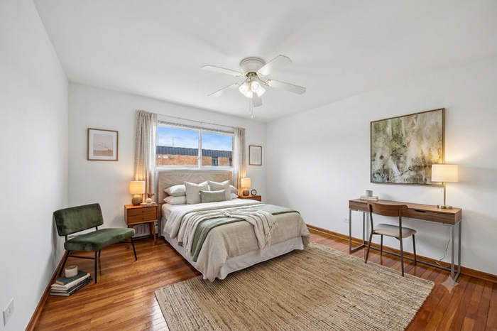Charming bedroom with elegant decor, featuring a comfortable bed, modern desk, and large window filling the space with natural light.