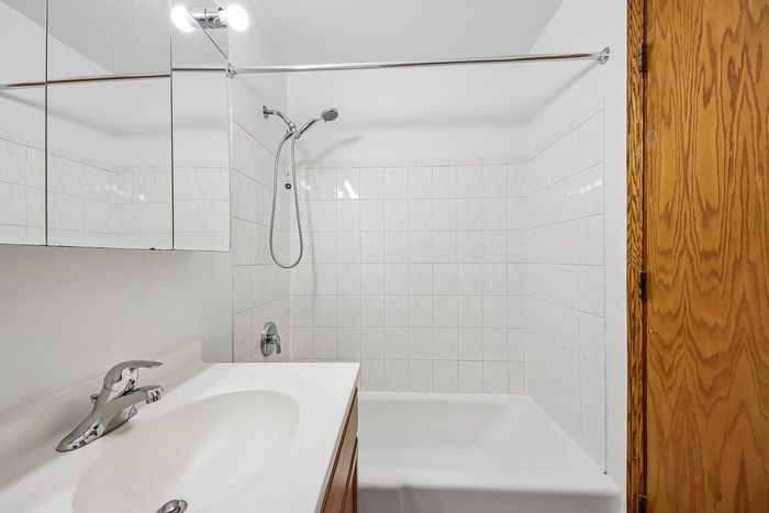 Bright and inviting bathroom with sleek tile design and modern fixtures, offering a luxurious and refreshing shower experience.