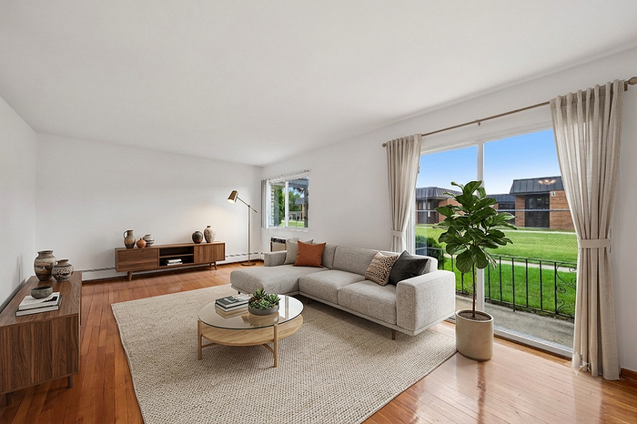 Chic living room with a large window view, featuring a cozy sectional sofa, stylish wood furniture, and vibrant indoor plant, bathed in natural light.