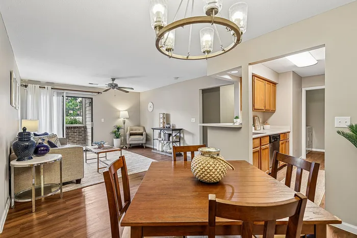 Inviting open-concept living space with elegant dining area, modern kitchen, and cozy lounge opening to a serene balcony.