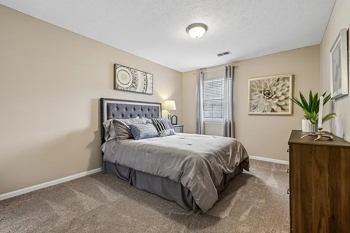 Inviting bedroom with a plush bed, elegant decor, and natural light filtering through the window, creating a cozy ambiance.
