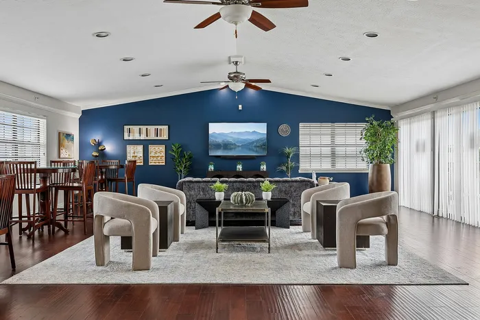 Elegant open-concept living room with modern decor, plush seating, and vibrant blue accent wall, perfect for stylish relaxation.