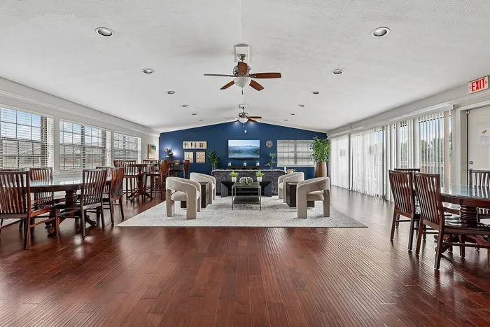 Spacious and elegant communal room with hardwood floors, modern seating, and ample natural light from large windows.