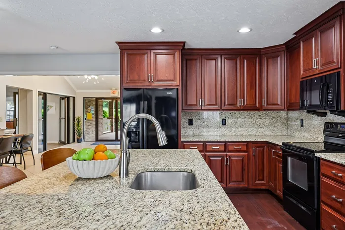 Modern kitchen with elegant granite countertops, rich wooden cabinets, and sleek stainless steel fixtures, creating a warm and inviting space.
