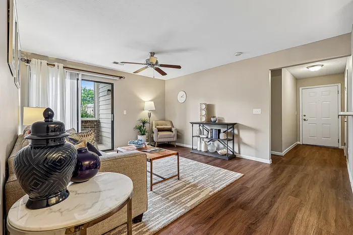 Inviting living room with elegant decor, plush sofa, and sliding glass door opening to a serene patio.