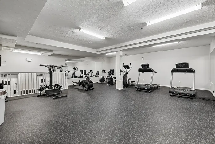 Modern gym with state-of-the-art equipment, including treadmills and elliptical machines, in a bright, spacious environment.