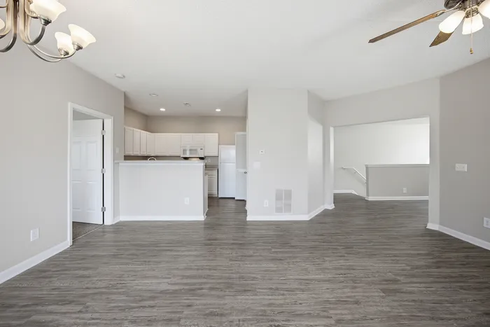 Spacious open-plan apartment with elegant hardwood flooring, modern kitchen, and natural light-filled interiors for a welcoming atmosphere.