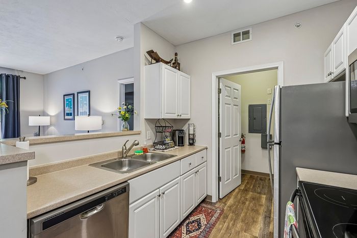 Modern kitchen with sleek stainless steel appliances, ample counter space, and chic white cabinetry, offering a bright and welcoming atmosphere.