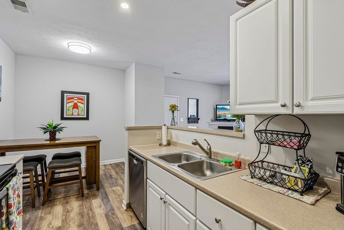 Charming kitchen showcasing modern fixtures, a stylish breakfast bar, and inviting wood flooring in a bright, open-concept space.
