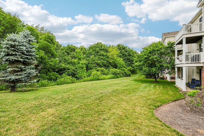Serene apartment view showcasing lush green landscape with vibrant trees and a spacious balcony, perfect for nature lovers.