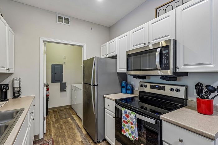 Modern kitchen with stainless steel appliances, sleek cabinetry, and warm tones, offering a functional yet stylish cooking space.