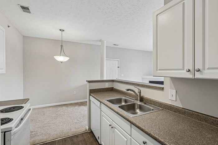 Charming kitchen view showcasing modern countertops, sleek double sink, and bright open space perfect for entertaining.