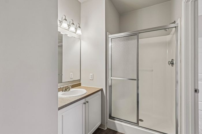 Modern bathroom with sleek shower enclosure, elegant vanity, and bright lighting, offering a fresh and inviting atmosphere.