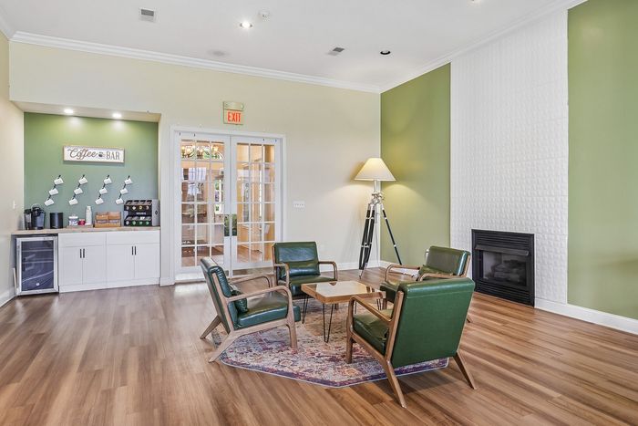Inviting common area with cozy seating, stylish accent wall, and coffee bar, perfect for relaxation and socializing.