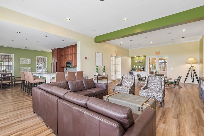 Spacious and elegant lounge area with comfortable leather seating, modern decor, and a coffee bar, ideal for relaxation and social gatherings.