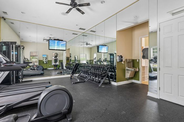 Modern fitness center with state-of-the-art gym equipment, mirrored walls, and sleek design for an ultimate workout experience.