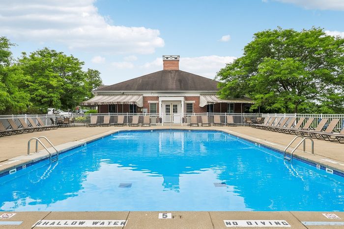 Inviting outdoor pool area with comfortable lounge chairs and lush greenery, perfect for relaxation and leisure.