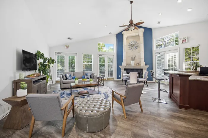 Gorgeous open living area with high ceilings, modern decor, vibrant accents, and abundant natural light.