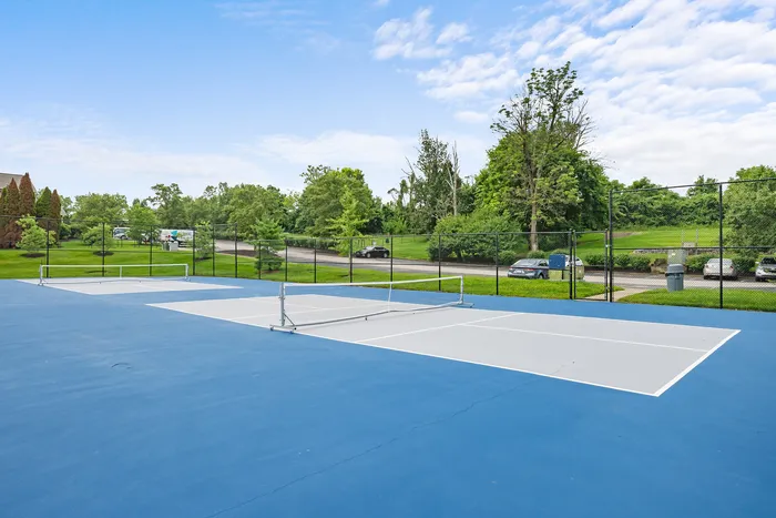 Vibrant outdoor pickleball courts surrounded by lush greenery, perfect for active living and enjoying sunny days.