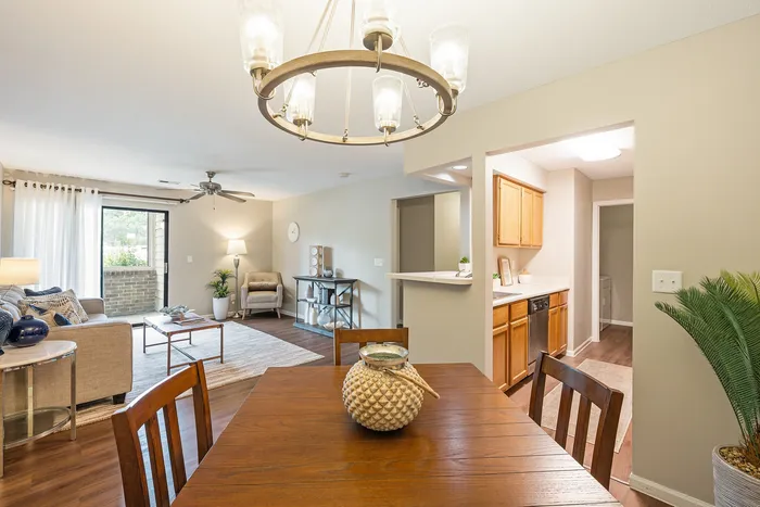 Inviting open-concept living area with elegant dining space, cozy seating, and bright kitchen in a modern apartment.