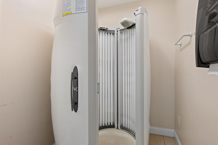 Compact and modern indoor tanning booth with sleek design, ideal for home wellness spaces.