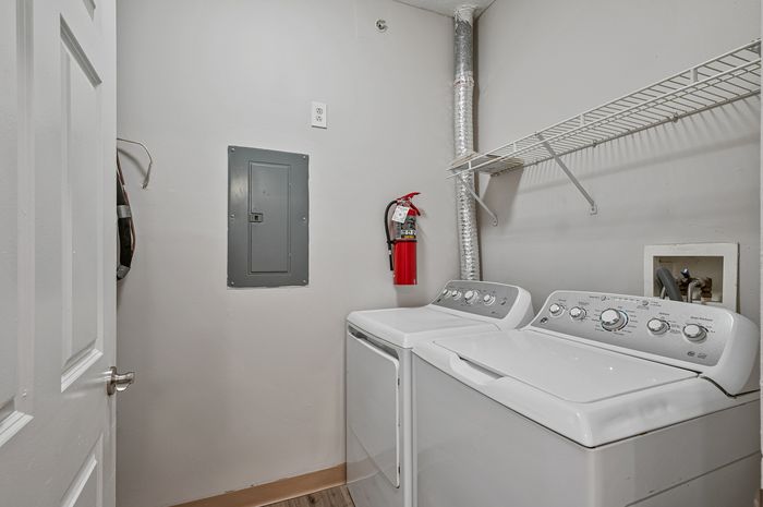 Modern laundry room featuring energy-efficient washer and dryer with convenient shelving and stylish design.