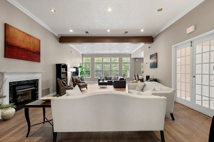 Elegant living room with cozy seating, fireplace, and abundant natural light from large windows, ideal for relaxation and entertaining.