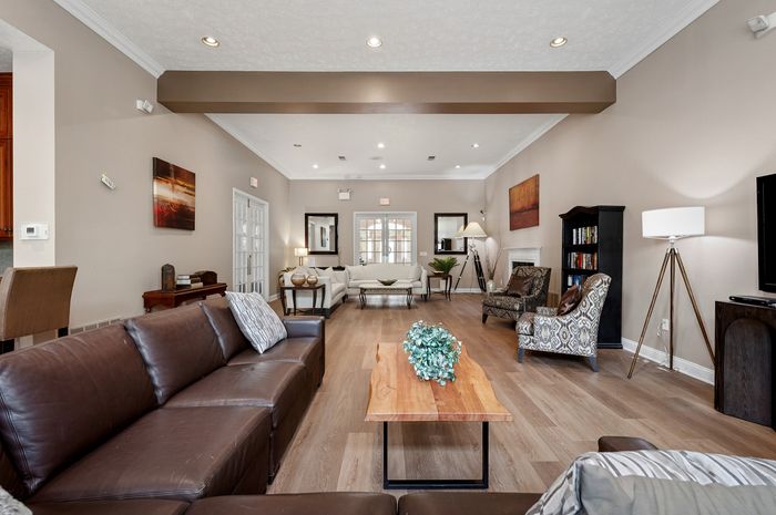 Elegant and spacious living room featuring modern leather sofas, warm wooden flooring, and stylish decor accents.