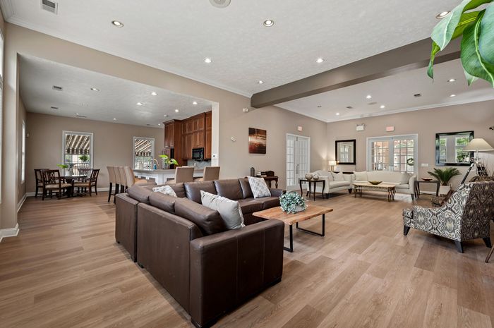 Modern and inviting living space with open-plan design, featuring elegant hardwood floors, cozy seating with plush sofas, and a spacious dining area, perfect for entertaining.