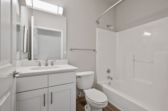 Sleek, modern bathroom with white fixtures, elegant vanity, and spacious tub.